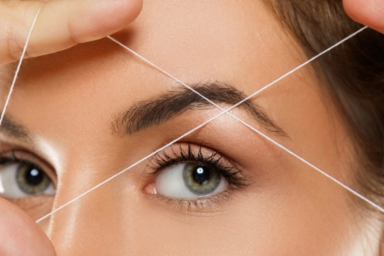 A professional beautician at Shrees Beauty Parlour in Kathreguppe, Banashankari 3rd Stage, Bengaluru, expertly shaping a client's eyebrows."